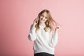 Beautiful young girl on a pink background in the studio speaks by phone. Royalty Free Stock Photo