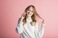 Beautiful young girl on a pink background in the studio speaks by phone. Royalty Free Stock Photo