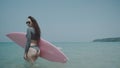 Beautiful young girl with pink surfboard during summer holidays Royalty Free Stock Photo