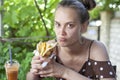 Beautiful young girl with pleasure eating a hamburger Greek gyros, girl in a dress sitting in a street cafe, eating a hamburger Royalty Free Stock Photo