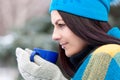 Beautiful young girl portrait on winter background. A charming young lady walking in a winter forest. Attractive woman with Cup. Royalty Free Stock Photo