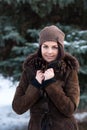 Beautiful young girl portrait on winter background. Charming young lady walking in a winter forest. Attractive woman posing.