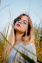 Beautiful young girl posing against high grass