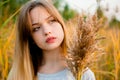 Beautiful young girl posing against high grass