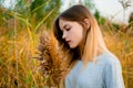 Beautiful young girl posing against high grass