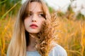 Beautiful young girl posing against high grass