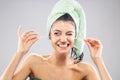 Beautiful young girl posing with towels after having a bath, holding cotton ear stick. Funny disgusted face expression Royalty Free Stock Photo