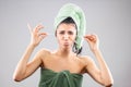 Beautiful young girl posing with towels after having a bath, holding cotton ear stick. Funny disgusted face expression Royalty Free Stock Photo