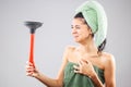 Beautiful young girl posing with towels after having a bath, holding red rubber suction cup. Funny disgusted face expression Royalty Free Stock Photo