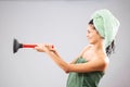 Beautiful young girl posing with towels after having a bath, holding red rubber suction cup. Funny disgusted face expression Royalty Free Stock Photo