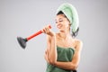 Beautiful young girl posing with towels after having a bath, holding red rubber suction cup. Funny disgusted face expression Royalty Free Stock Photo