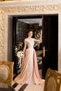 A beautiful young girl in a powdery wedding dress on the background of the interiors of a luxurious historical apartment. Royalty Free Stock Photo