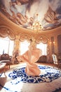 A beautiful young girl in a powdery wedding dress on the background of the interiors of a luxurious historical apartment. Royalty Free Stock Photo