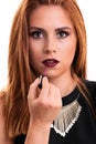 Beautiful young girl putting lipstick Royalty Free Stock Photo