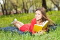 Beautiful young girl reads book in park Royalty Free Stock Photo