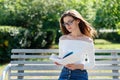 Beautiful young girl reads a book in park outdoors Royalty Free Stock Photo