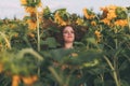 Beautiful young girl with red wavy hair and freckles in stripped colourful dress enjoying nature on the field of sunflowers. Royalty Free Stock Photo