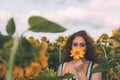 Beautiful young girl with red wavy hair and freckles in stripped colourful dress enjoying nature on the field of sunflowers. Royalty Free Stock Photo