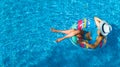 Beautiful young girl relaxing in swimming pool, swims on inflatable ring and has fun in water on family vacation