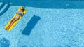 Beautiful young girl relaxing in swimming pool, swims on inflatable mattress and has fun in water on family vacation, aerial view Royalty Free Stock Photo