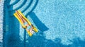 Beautiful young girl relaxing in swimming pool, swims on inflatable mattress and has fun in water on family vacation Royalty Free Stock Photo