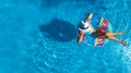 Beautiful young girl relaxing in swimming pool, swims on inflatable ring and has fun in water on family vacation