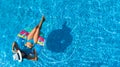 Beautiful young girl relaxing in swimming pool, swims on inflatable ring and has fun in water on family vacation