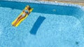 Beautiful young girl relaxing in swimming pool, woman swims on inflatable mattress and has fun in water on family vacation Royalty Free Stock Photo