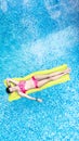 Beautiful young girl relaxing in swimming pool, woman swims on inflatable mattress and has fun in water on family vacation Royalty Free Stock Photo