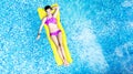 Beautiful young girl relaxing in swimming pool, woman swims on inflatable mattress and has fun in water on family vacation Royalty Free Stock Photo