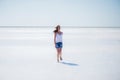 Beautiful young girl runs and smiles on a dry salt lake in summer at noon Royalty Free Stock Photo