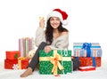 Beautiful young girl in santa hat with a glass of champagne and gift boxes Royalty Free Stock Photo