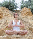 A beautiful young girl with short hair is dressed in shorts and a white jersey is practicing yoga Royalty Free Stock Photo