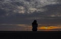 A beautiful young girl is showing the sunset in the water.