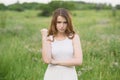 Beautiful young girl shows discontent in nature.