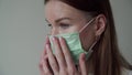 Beautiful young girl shows how to put on a medical mask privately. Orvi, coronovirus, flu, acute respiratory disease.