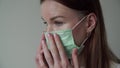 Beautiful young girl shows how to put on a medical mask privately. Orvi, coronovirus, flu