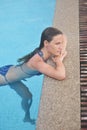 Beautiful young girl sit and relaxing in a blue pool Royalty Free Stock Photo