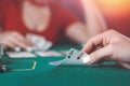 beautiful young girl sits at a poker table with cards in her hands and a player opposite. poker game of chance Royalty Free Stock Photo