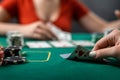 beautiful young girl sits at a poker table with cards in her hands and a player opposite. poker game of chance Royalty Free Stock Photo