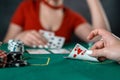 beautiful young girl sits at a poker table with cards in her hands and a player opposite. poker game of chance Royalty Free Stock Photo