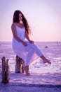 Beautiful young girl sitting on the fence on the salt lake Royalty Free Stock Photo