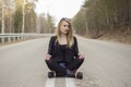 Beautiful young girl sitting in the middle of the road. Royalty Free Stock Photo