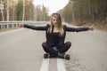 Beautiful young girl sitting in the middle of the road. Royalty Free Stock Photo