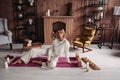 Beautiful young girl sitting relaxing on mat with candles in stylish cozy comfort home interior with comfy furniture Royalty Free Stock Photo