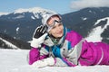 Beautiful young girl in ski suit lying in the snow Royalty Free Stock Photo
