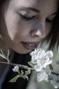 Beautiful young girl smelling a twig of blooming plum flowers Royalty Free Stock Photo