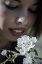 Beautiful young girl smelling a twig of blooming plum flowers Royalty Free Stock Photo