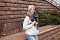 Beautiful young girl with a smile in warm clothes and jeans