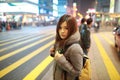 Beautiful young girl stand out and watching at night in hong kong, lost in city , busy crowd